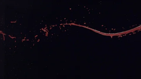 Thin stream of red fluid splashing and pouring across screen in slow motion B Stock Footage 109571614