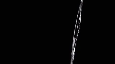 Thin Stream Of Water Pouring On Black Background. Close-up Stock Footage 312013227