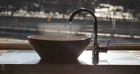A thin stream of water pours into the sink on the windowsill Stock Footage 139587982