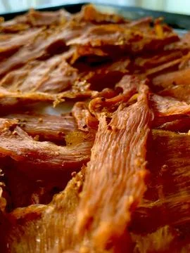 Thin strips of marinated meat bask in sunlight, drying and absorbing flavors. Foto stock