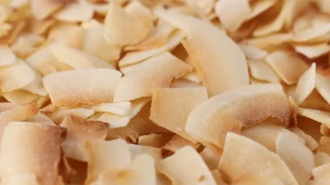Thin sweet toasted coconut chips circle rotation close up Stock Footage 276380753