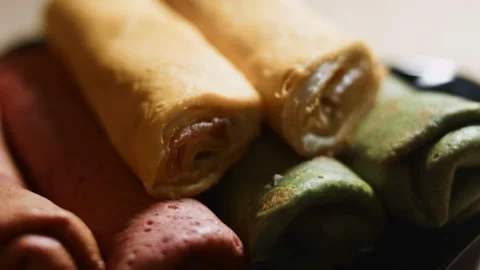 Thin tasty colorful pancakes. Macro view of red, yellow and green rolled Stock Footage 144895320