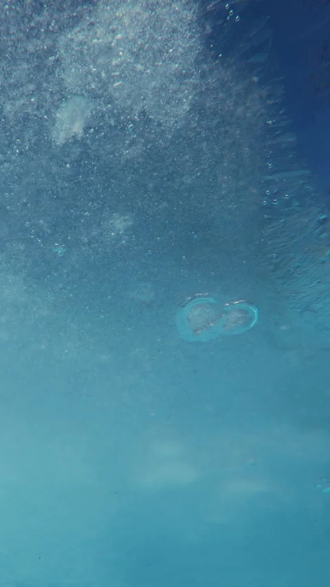 Thin thawing spring clear ice with frozen air bubbles floating downstream along Vídeo Stock 338024843