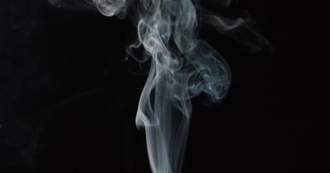 Thin tower of smoke against dark background Stock Photos