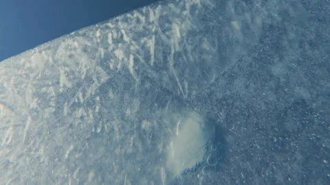 Thin transparent edge of spring melt ice with air bubbles frozen into it slowly Stock Footage 311568644