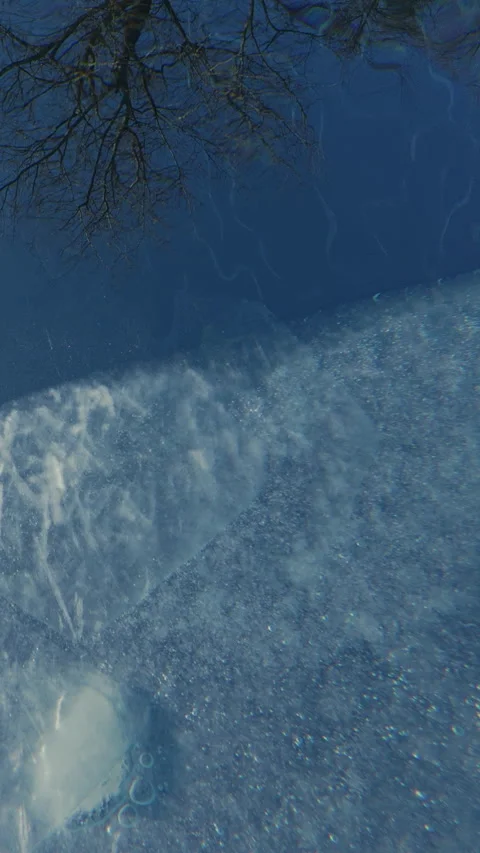 Thin transparent edge of spring melt ice with air bubbles frozen into it slowly Stock Footage 311569667