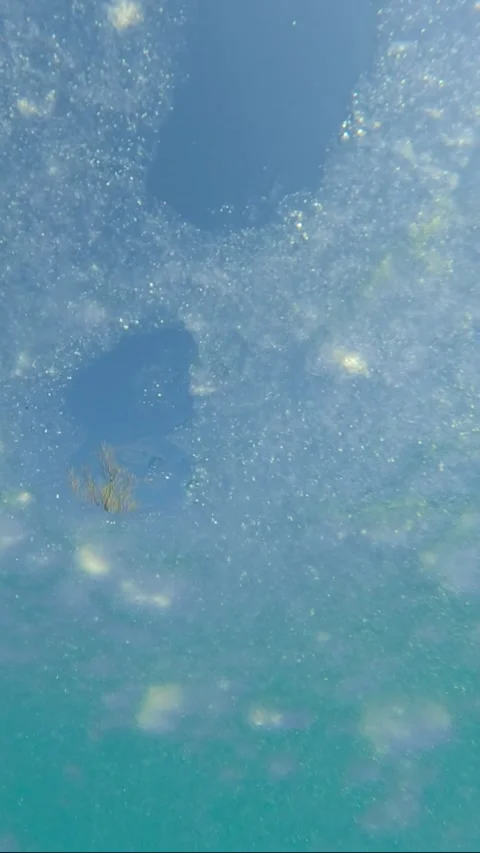 Thin transparent ice floats on surface of water on turquoise sky background Stock Footage 304983509