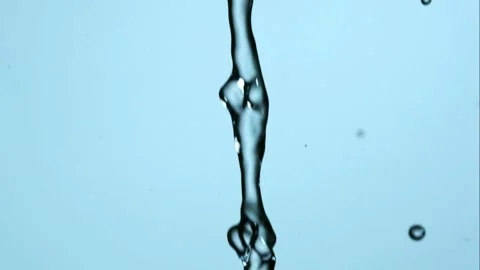 A thin vertical water stream breaks into droplets in slow motion Stock Footage 326625401