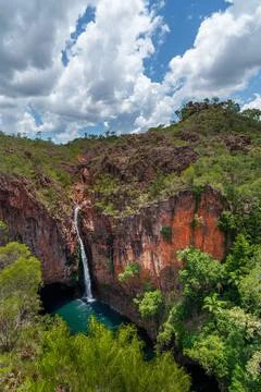 Thin waterfall plummets down into the turquoise lake below 写真素材