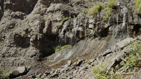 Thin waterfall streams over layered rock wall in Colorado Stock-Footage 348025327