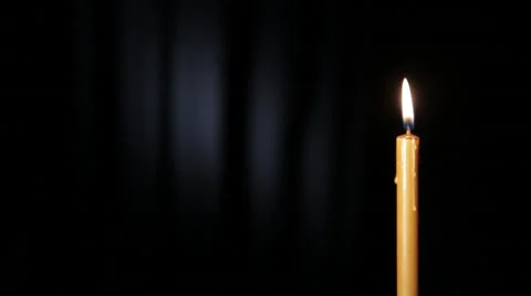 Thin wax candle burning on a black background with white beam Stock Footage 46952579