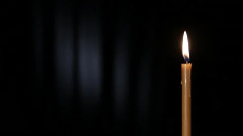 Thin wax candle burning on a black background with white beam Stock Footage 46952779