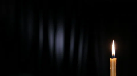 Thin wax candle burning on a black background with white beam Stock Footage 46953127