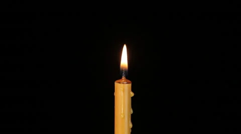 Thin wax candle burning on a black background. Close-up. Stock Footage 46953816