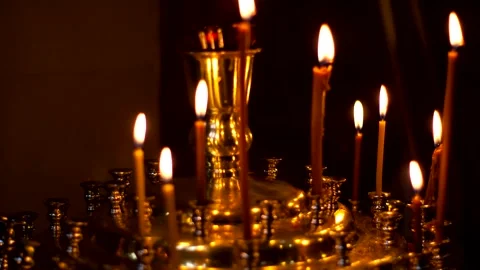 Thin wax candles burn on stands Stock Footage 334582544