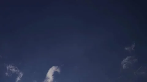 Thin white clouds drift across a wide blue sky Stock Footage 329756530