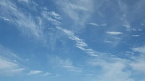 Thin white summer clouds drifting through a blue sky towards from the viewer Stock Footage 311128626