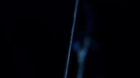 A thin winch cable moving in dim light on a dark stage, with a moody and Stock Footage 296577657