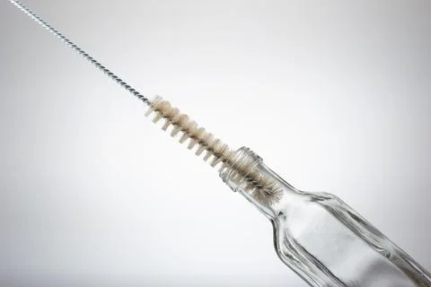 Thin wire brush for cleaning bottles. Inside small empty glass bottle. Close  Stock-Fotos