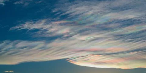 Thin wispy clouds creating rainbow patterns of scattered sunlight. Optical ph Stock Photos