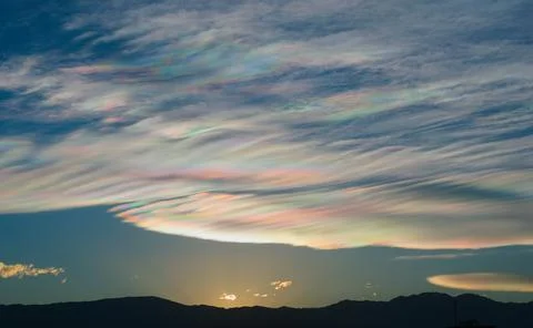 Thin wispy clouds creating rainbow patterns of scattered sunlight. Optical ph Stock Photos