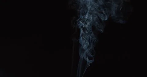 Thin wispy smoke trail over dark background Stock Photos