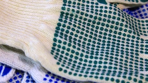 Thin work gloves with blue and green pimples on a rotating surface, Stock Footage 70827402