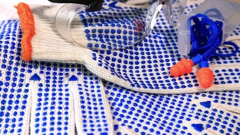 Thin work gloves with  blue pimples, protective glasses and ear plugs Stock Footage 70826414