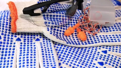 Thin work gloves with  blue pimples, protective glasses and ear plugs on a rotat Stock Footage 70826420