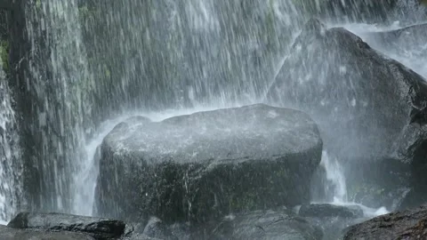 Thing stream of water falling on a rock from a isolated waterfall. Stock Footage 162150381