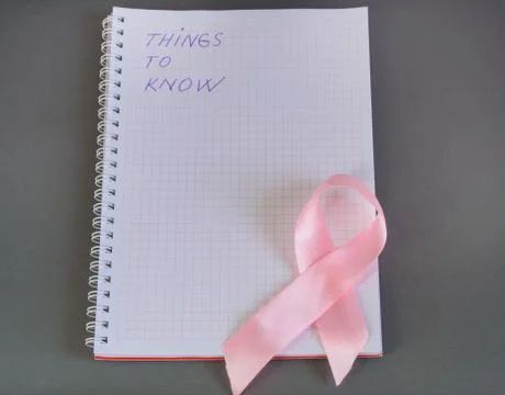 Things to know is written in Notepad with pink ribbon awareness breast cancer Stock Photos