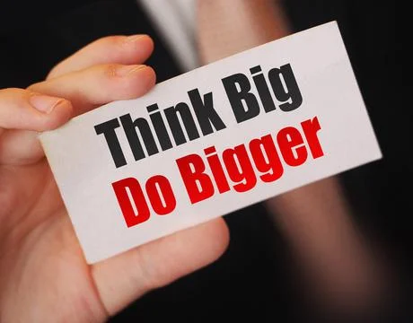 Think Big Do Bigger text. Businessman holds card. Business Motivation concept Stock Photos