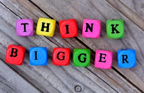 Think bigger words on table Stock Photos