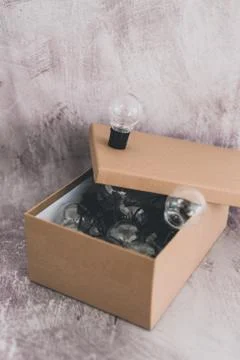 Think outside the box lightbulbs inside and a unique one on top of it Stock Photos