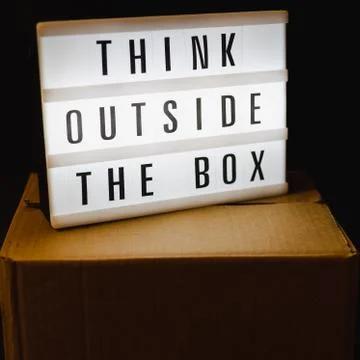 Think outside the box message on lightbox on top of closed parcel Stock Photos