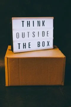 Think outside the box message on lightbox on top of closed parcel Stock Photos