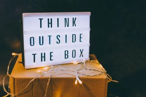 Think outside the box message on lightbox on top of closed parcel with fairy  Stock Photos