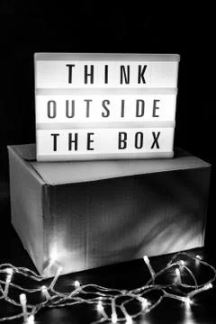 Think outside the box message on lightbox on top of closed parcel with fairy  Stock Photos