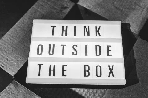 Think outside the box message on lightbox on top of open parcel Stock Photos