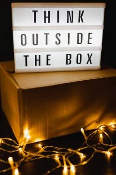 Think outside the box message on lightbox on top of closed parcel with fairy  Stock Photos