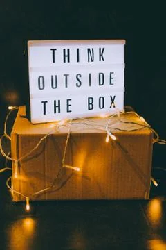 Think outside the box message on lightbox on top of closed parcel with fairy  Stock Photos