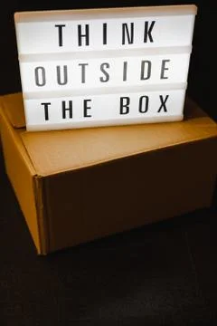 Think outside the box message on lightbox on top of closed parcel Stock Photos