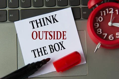 THINK OUTSIDE THE BOX on a white sheet against the background of the comput.. Stock Photos