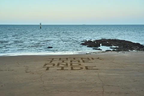 Think time and tide warning message on a beach Stock Photos