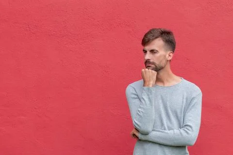 Thinker pose of man on isolated red wall background Stock Photos