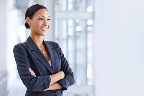Thinking about her future. A young businesswoman looking away thoughtfully. Stock Photos