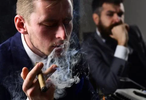 Thinking about problem solution. Thoughtful man smoking cigar. Businessmen hold Stockfoto's