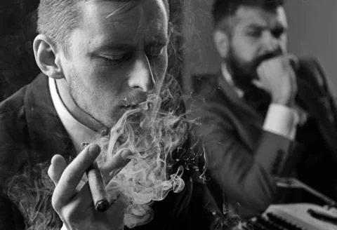 Thinking about problem solution. Thoughtful man smoking cigar. Businessmen hold Stockfoto's