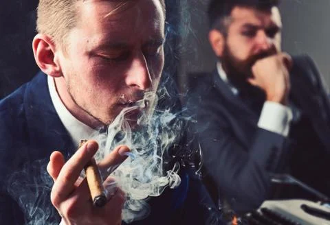 Thinking about problem solution. Thoughtful man smoking cigar. Businessmen hold Stockfoto's