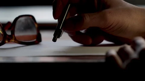 Thinking and writing working at desk with pen and paper. Stock Footage 307444070